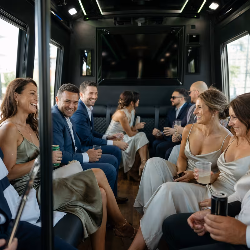 Wedding guests seated inside a New Orleans party bus