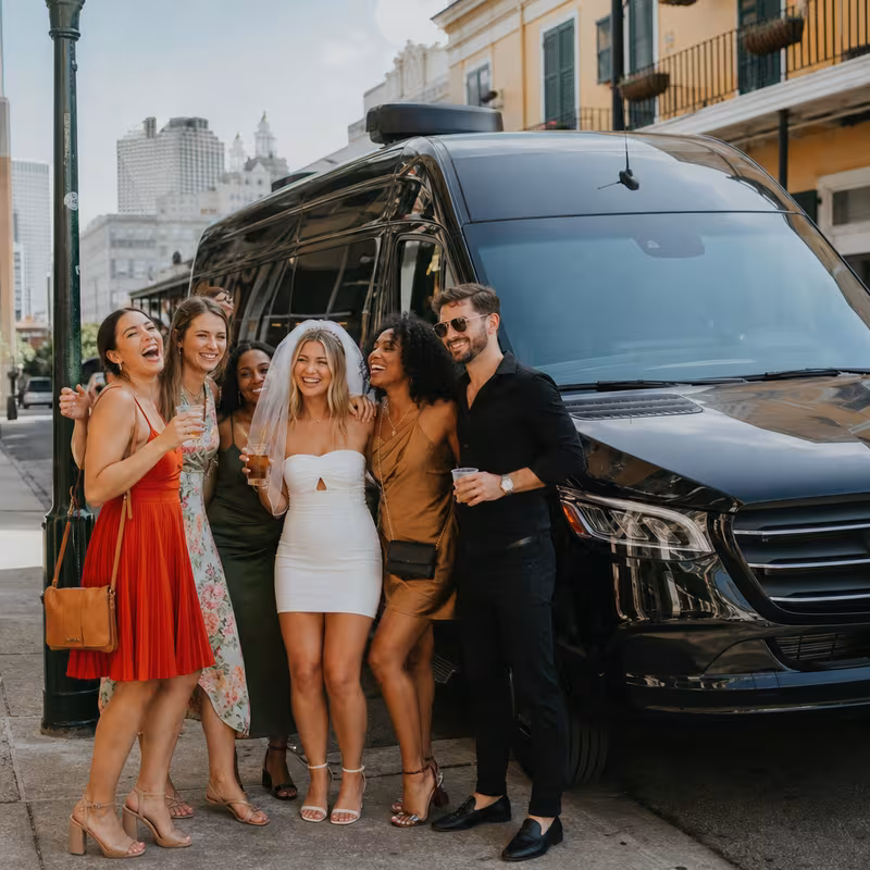 Group boarding a white charter bus for Bachelor & Bachelorette Transportation transportation in New Orleans