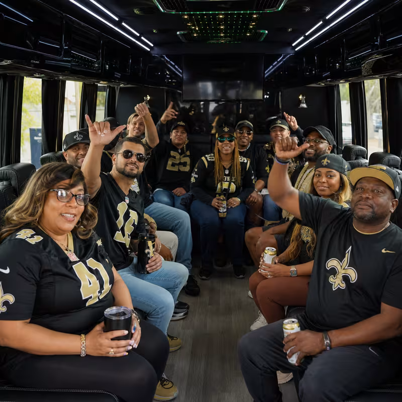 Group boarding a white charter bus for Sporting Event Transportation transportation in New Orleans